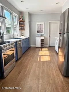 a kitchen with stainless steel appliances a stove top oven and a refrigerator