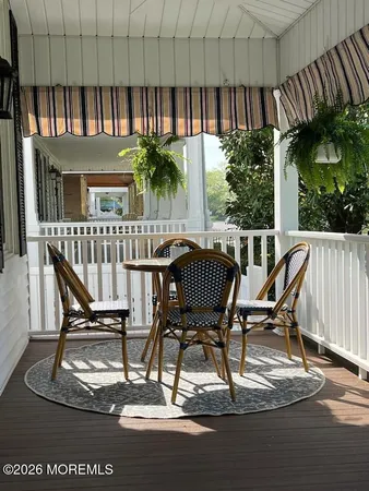 a view of a patio with table and chairs with wooden floor and fence