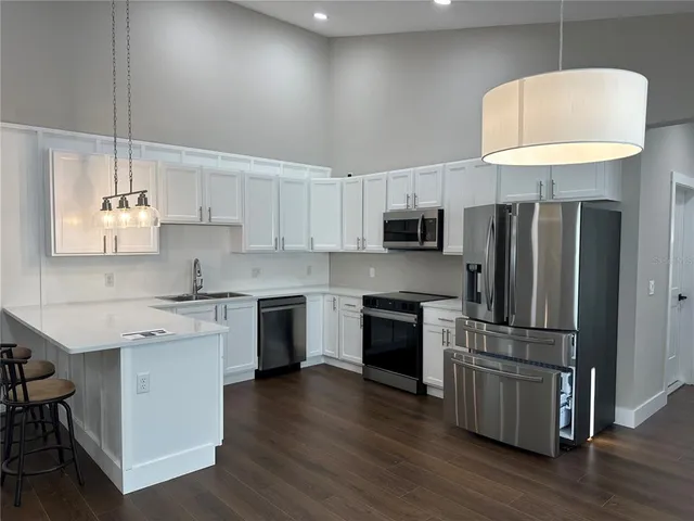 a kitchen with kitchen island granite countertop a sink a counter space stainless steel appliances and cabinets