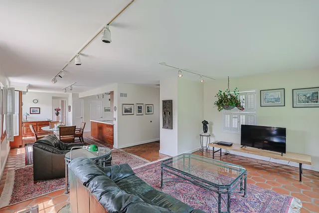 a living room with furniture a flat screen tv and a table