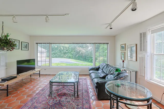 a living room with furniture a table and a large window