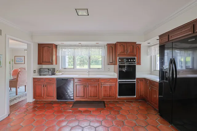 a large kitchen with stainless steel appliances granite countertop a refrigerator and a stove top oven