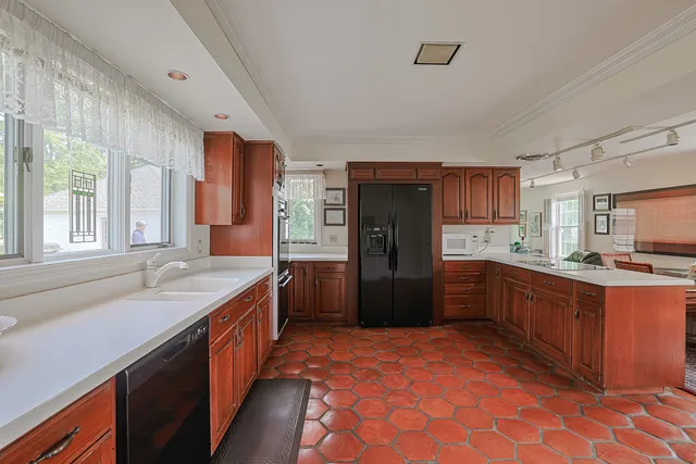 a large kitchen with stainless steel appliances kitchen island granite countertop a sink and cabinets