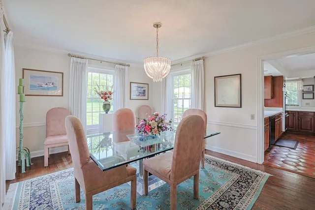 a dining room with furniture a chandelier and wooden floor
