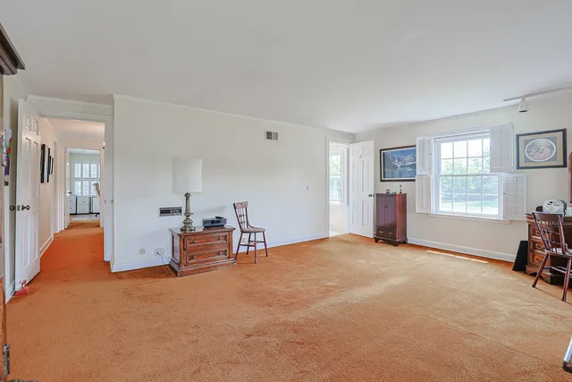 a view of an empty room with a window and a bedroom