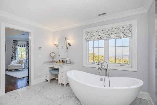 a spacious bathroom with a tub and 2 sink