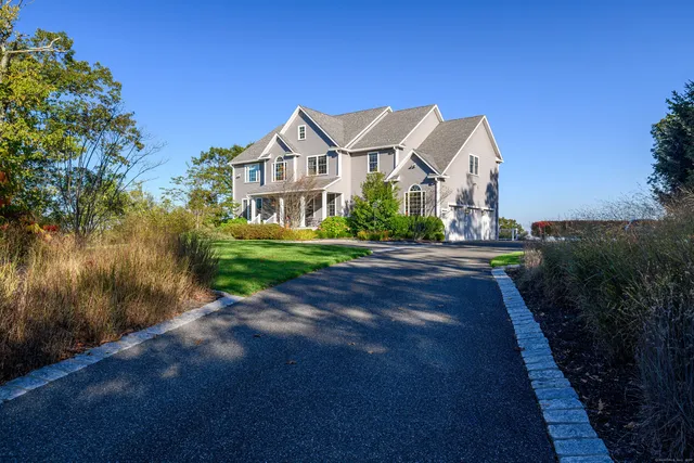 a front view of a house with a yard and green space