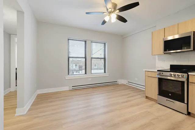 a view of an empty room with kitchen microwave and stove top oven