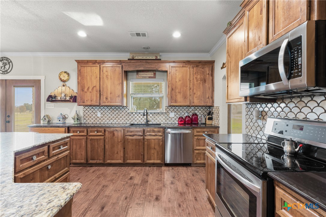 452 County Road 470 Chilton, TX 76632 - Photo 8 of 47 a kitchen with stainless steel appliances granite countertop a stove a sink and a microwave
