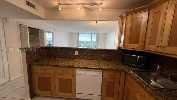 a kitchen with granite countertop a sink and cabinets