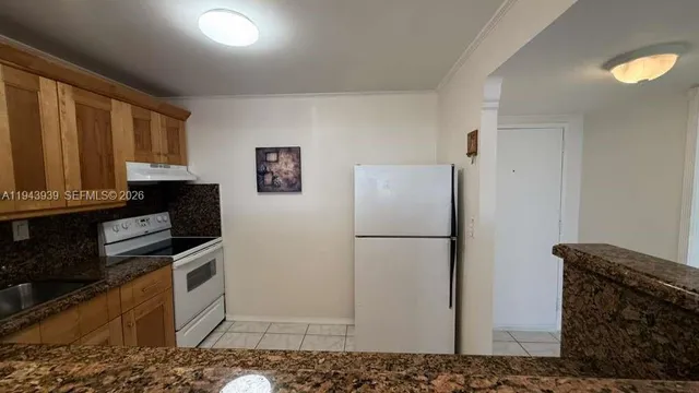 a white refrigerator freezer and a stove in a kitchen