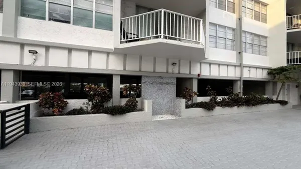 a view of a building with cars parked