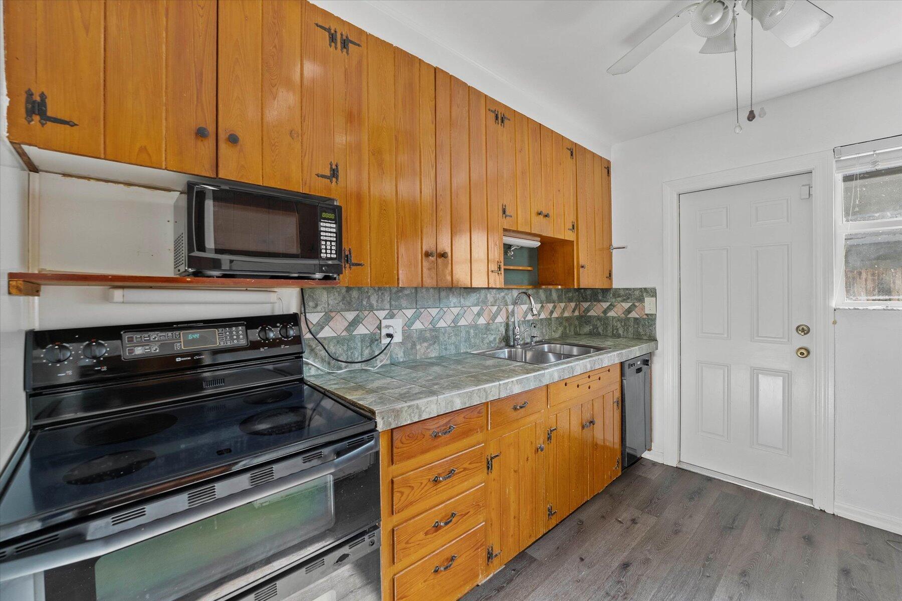 101 South Colorado Avenue Stuart, FL 34994 - Photo 10 of 17 a kitchen with stainless steel appliances granite countertop a stove microwave and cabinets
