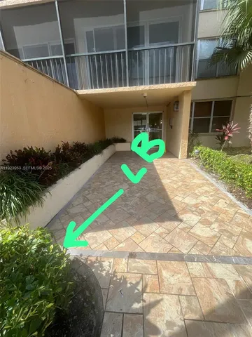 a front view of a house with a yard and potted plants