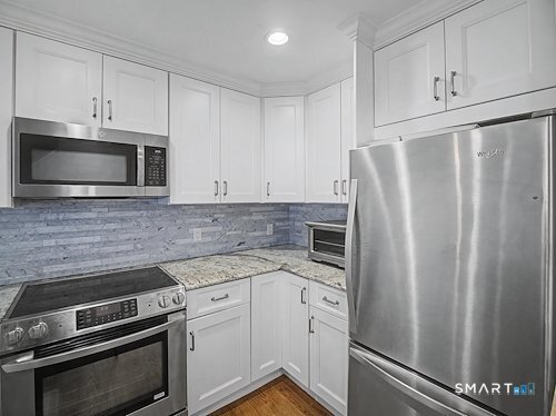 9 River Road, Unit 418 Greenwich, CT 06807 - Photo 12 of 38 a kitchen with appliances a sink and cabinets