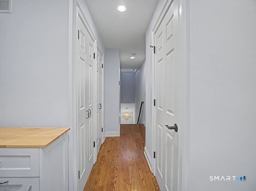 9 River Road, Unit 418 Greenwich, CT 06807 - Photo 14 of 38 a view of a hallway with wooden floor and a bathroom