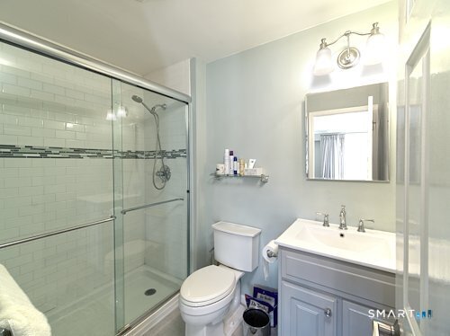 9 River Road, Unit 418 Greenwich, CT 06807 - Photo 26 of 38 a bathroom with a shower sink vanity mirror and toilet
