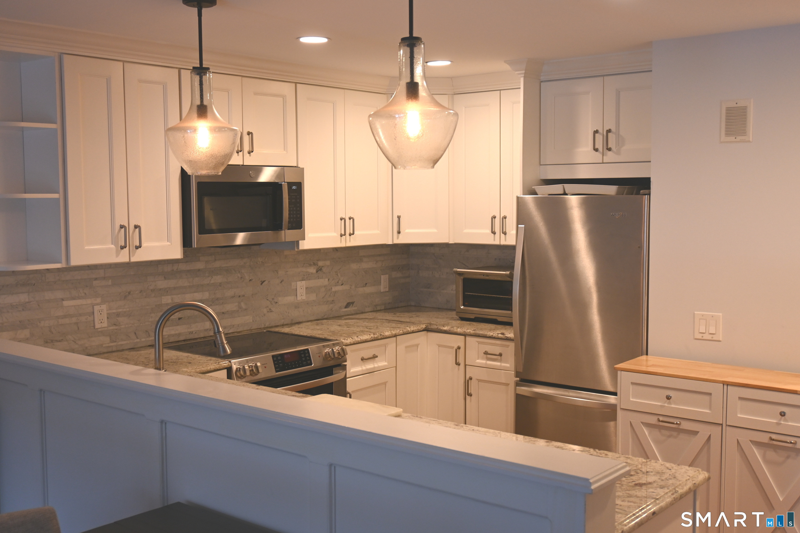 9 River Road, Unit 418 Greenwich, CT 06807 - Photo 5 of 38 a kitchen with stainless steel appliances a refrigerator sink and microwave
