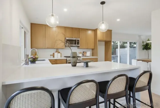 a kitchen with stainless steel appliances granite countertop a kitchen island a stove a table and chairs