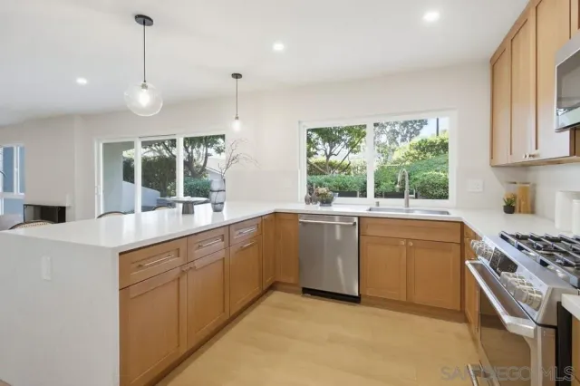 a kitchen with sink a stove and chairs