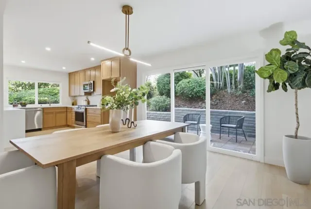 a dining room with furniture a potted plant and a chandelier