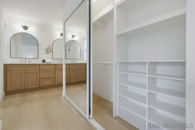a view of two sink and dishwasher with white cabinets