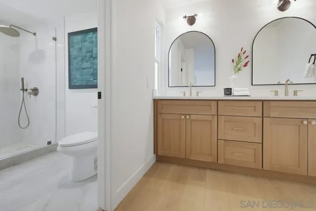 a bathroom with a double vanity sink toilet and a mirror