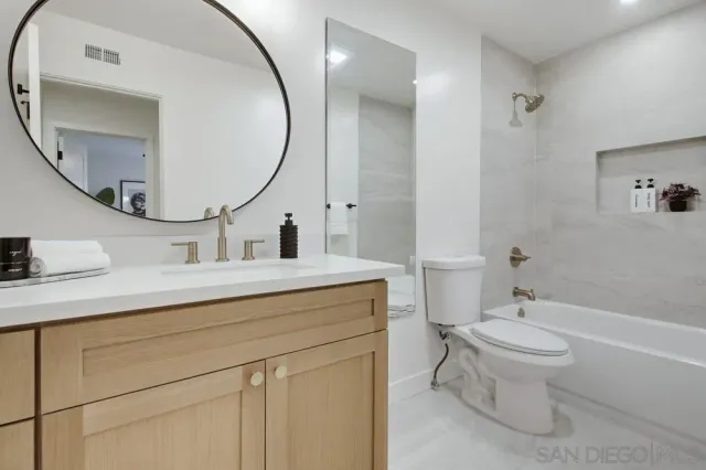 a bathroom with a sink a toilet and a mirror