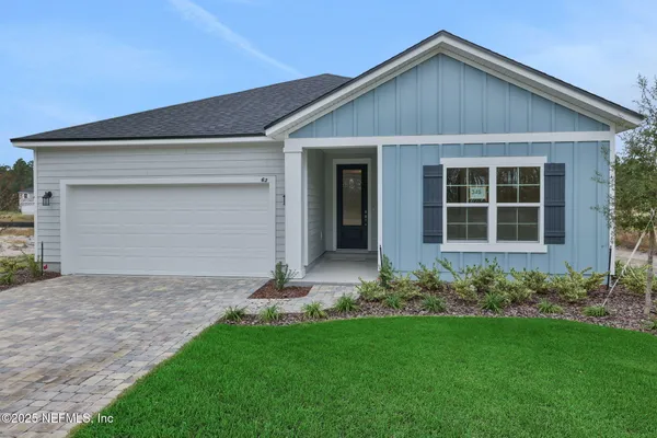 a front view of a house with a garden and yard