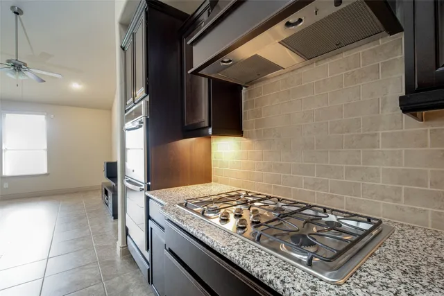 a kitchen with stainless steel appliances granite countertop a sink and a refrigerator