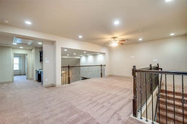 a hallway with stainless steel appliances granite countertop cabinets and empty counter top