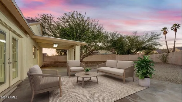 a view of a patio with couches table and chairs and potted plants