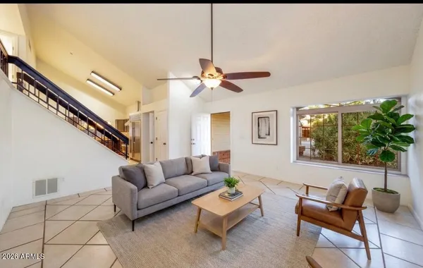 a living room with furniture a ceiling fan and a window