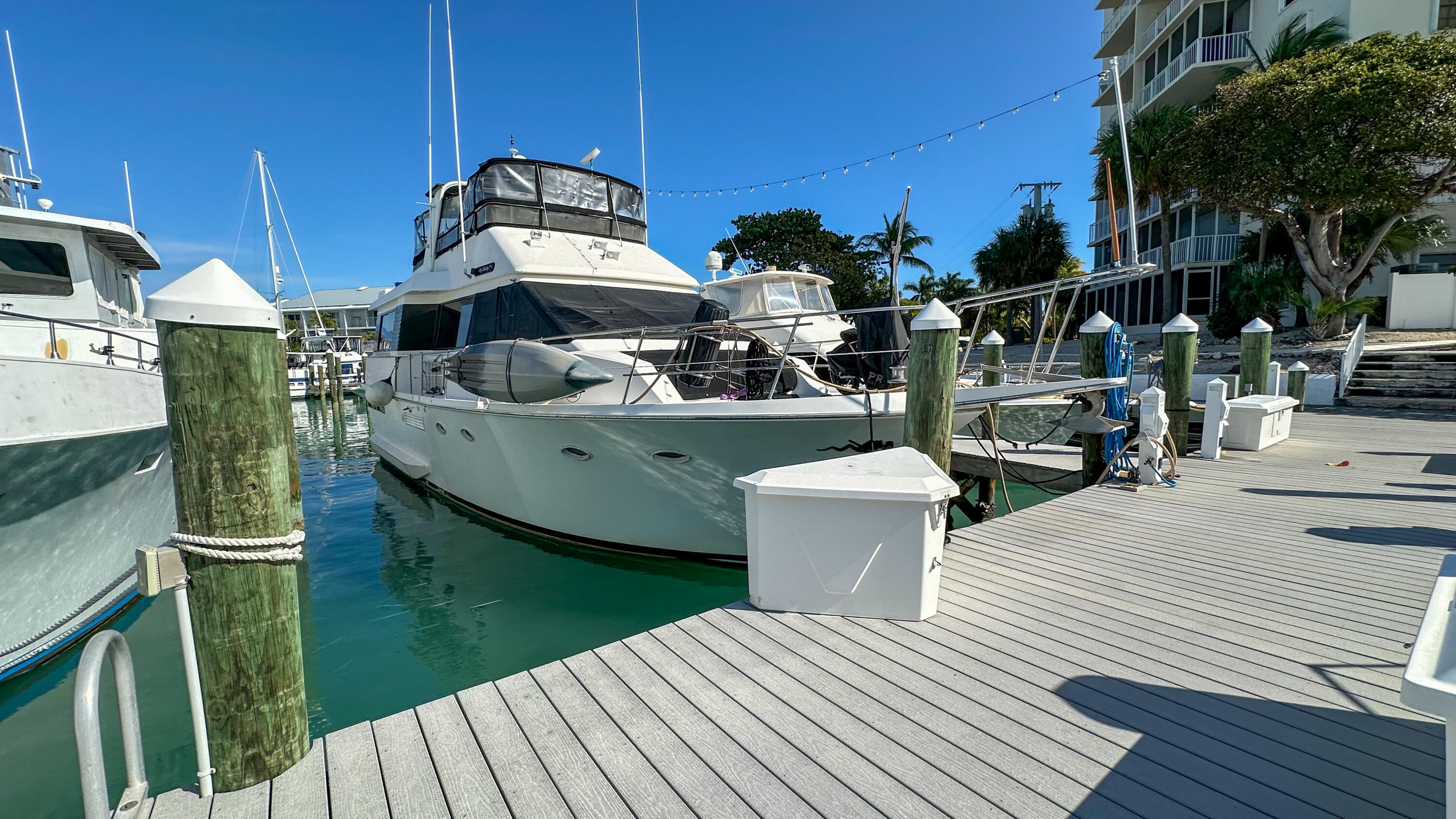 97 Coco Plum Drive, Unit T7 Marathon, FL 33050 - Photo 17 of 24 a view of a roof deck with table and chairs a barbeque with wooden floor and fence
