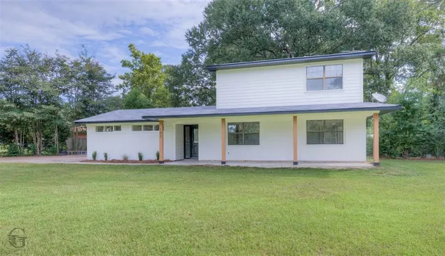 a front view of a house with a garden and yard