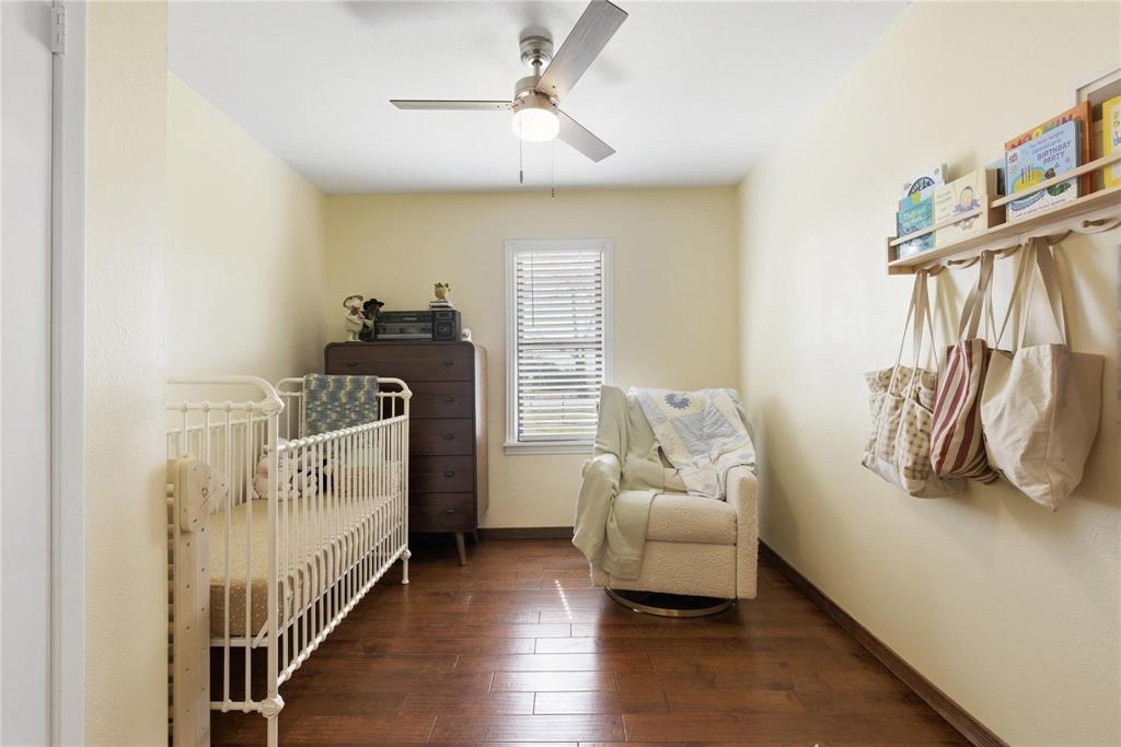 9213 Wilson Road Pilot Point, TX 76258 - Photo 25 of 36 Bright room featuring wood-finish flooring, a window with horizontal blinds, and a ceiling fan with integrated lighting
