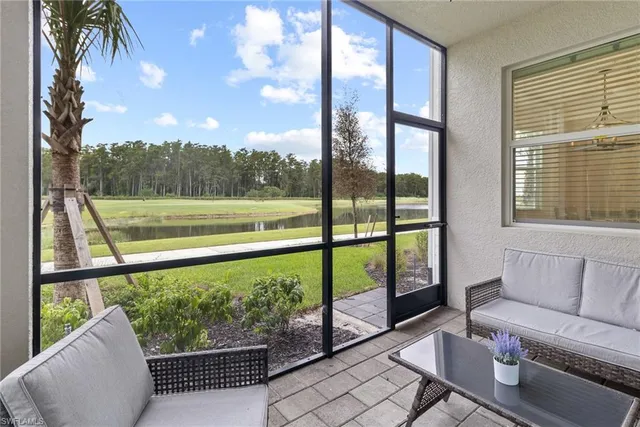 a living room with furniture and a floor to ceiling window