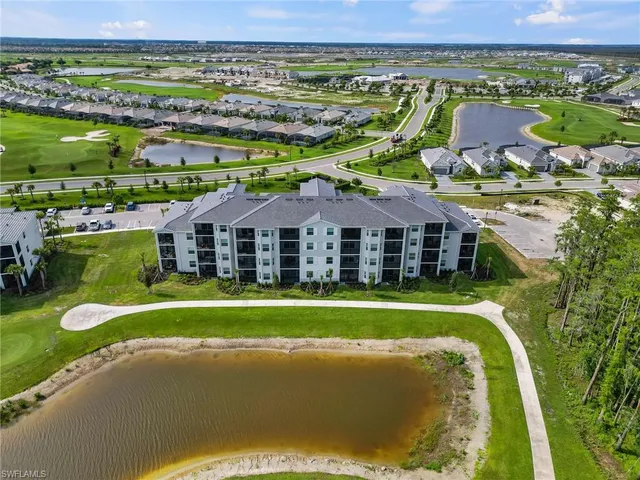 a view of a big building with a swimming pool and outdoor seating