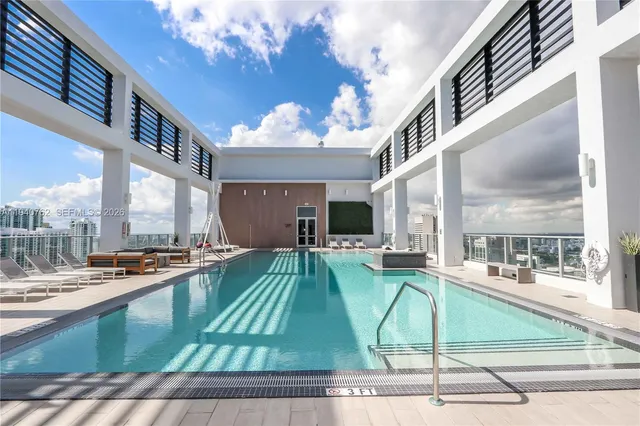 a living room with furniture a flat screen tv and a floor to ceiling window