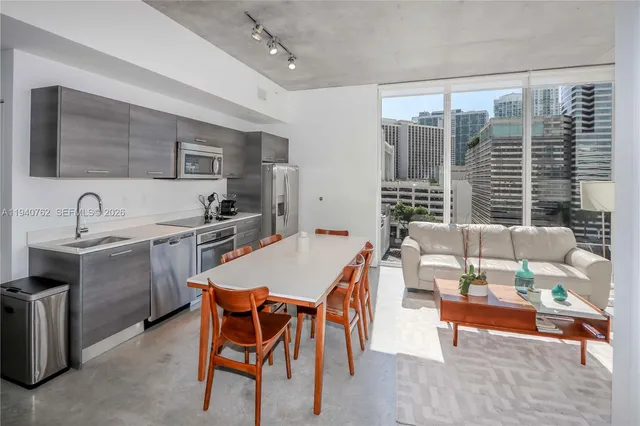 a dining room with a table chairs and a kitchen view