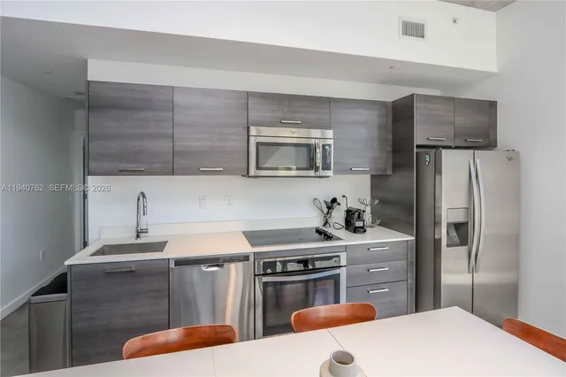 a kitchen with stainless steel appliances a stove refrigerator sink and microwave