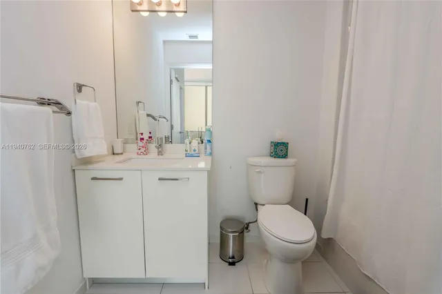 a bathroom with a toilet sink vanity and mirror