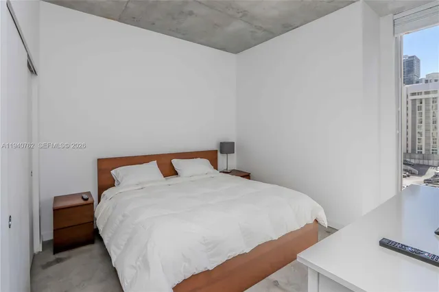 a large bed sitting in a bedroom next to a window