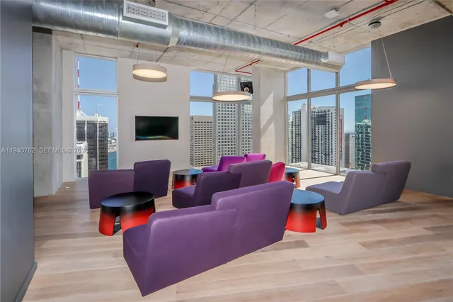 a living room with furniture a flat screen tv and a large window