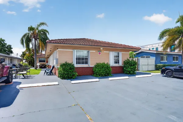 a view of a patio with table and chairs potted plants and palm tree