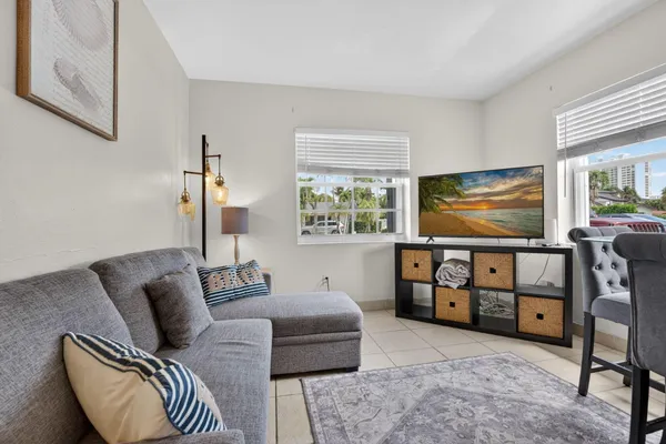 a living room with furniture a dining table and a flat screen tv