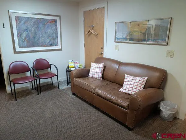 a living room with furniture and wall paintings