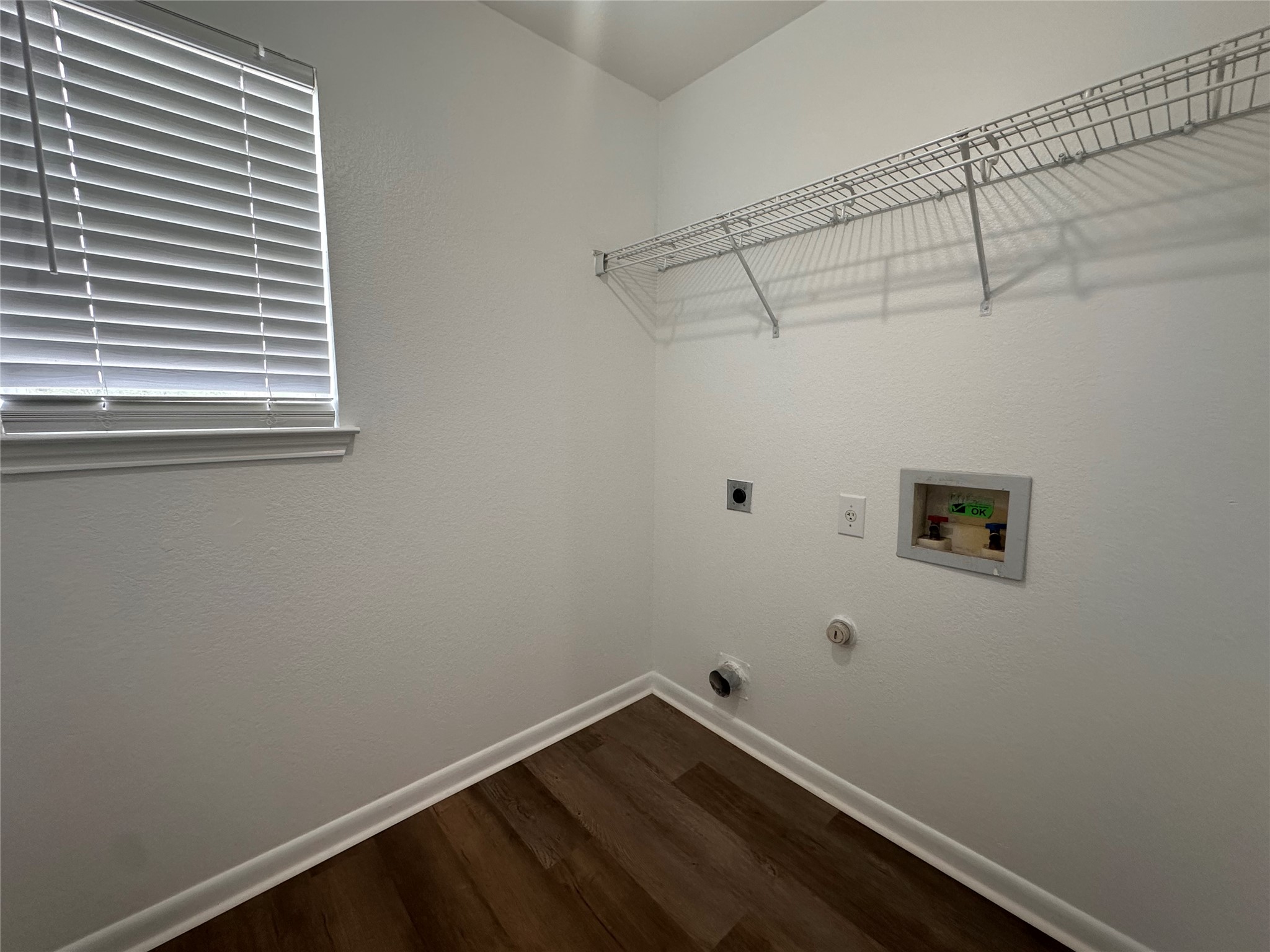 722 Lavaca Loop Elgin, TX 78621 - Photo 21 of 24 Laundry room with electric dryer hookup, dark wood-style flooring, hookup for a washing machine, and hookup for a gas dryer