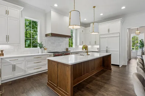 a kitchen with kitchen island granite countertop a sink appliances and cabinets