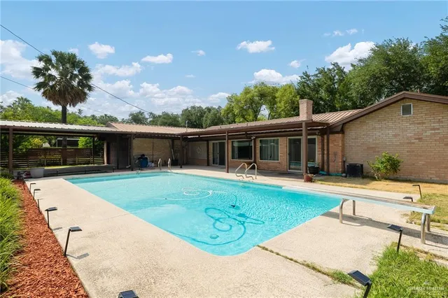 a view of a house with backyard sitting area and swimming pool